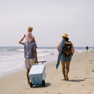 10% off coolers ad featuring a family walking on the beach dragging a blue cooler with them.